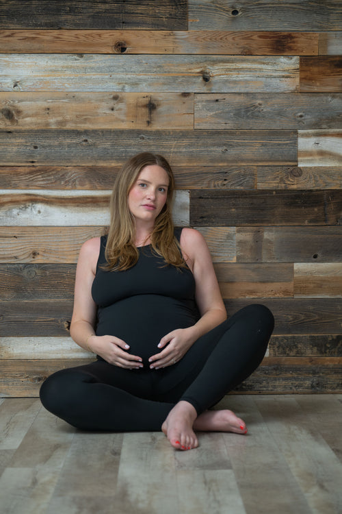 pregnant woman sitting cradling her belly